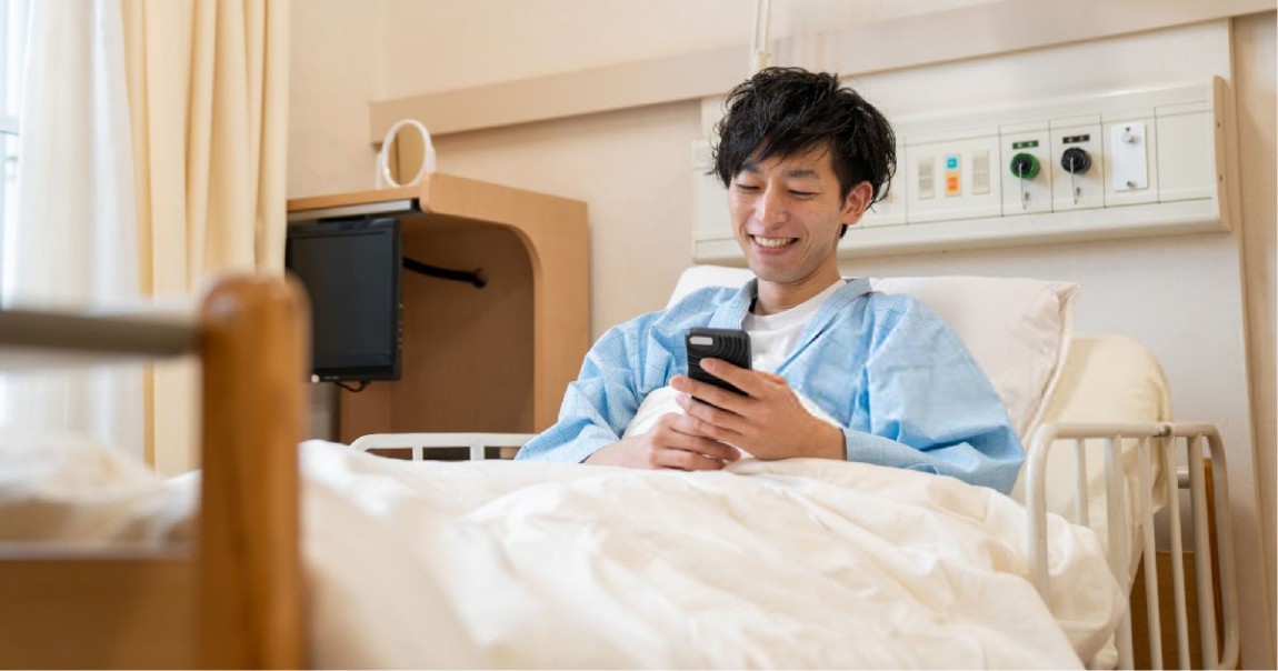 Patient smiles while looking at phone.