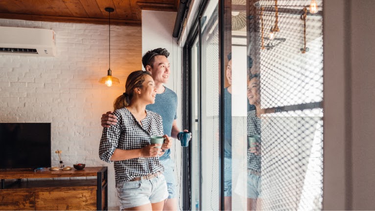 Couple look out their apartment view.