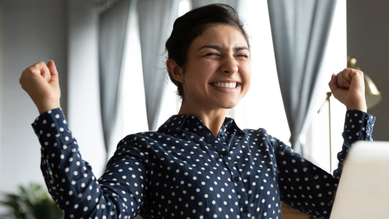 Girl celebrates in front of her laptop.