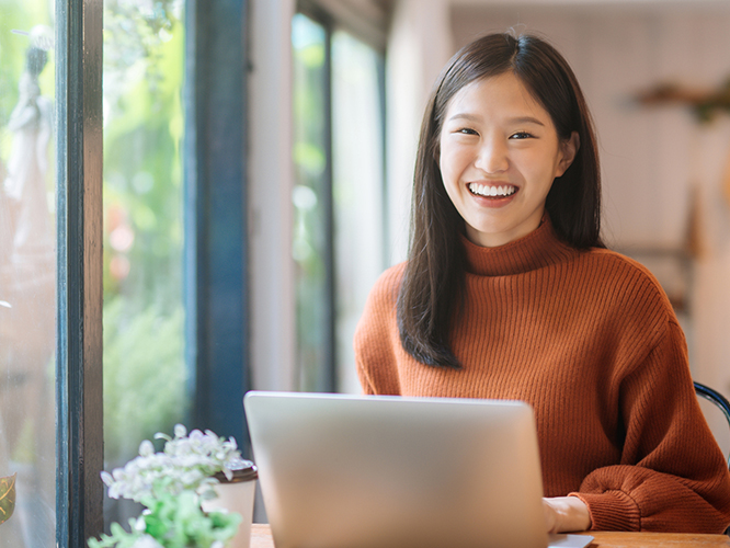 Woman smiles while using her laptop