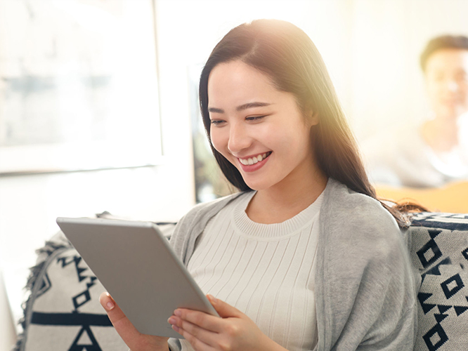 Girl browsing tablet on sofa