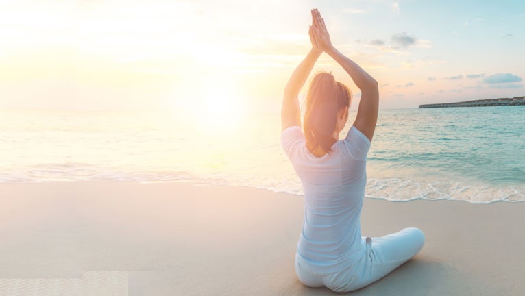 Girl doing yoga by the beach