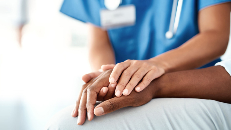 Nurse holding patient’s hand
